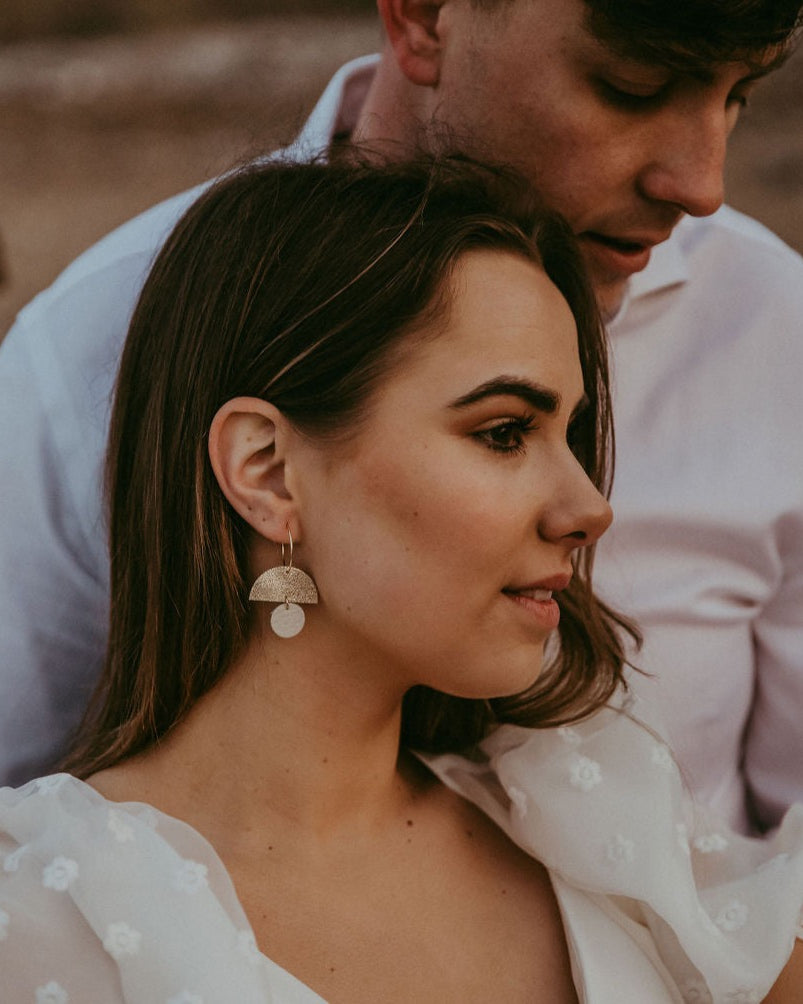 Bride and groom on their wedding day, bride wears gold and cream moon shaped statement hoop earrings.