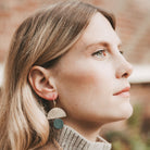 Model wearing the leather sunrise hoops in forest green