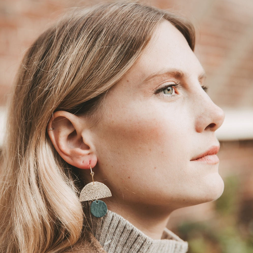 Model wearing the leather sunrise hoops in forest green