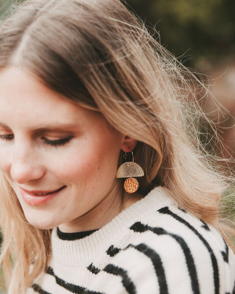 Model wearing the leather sunrise hoop earrings in metallic copper