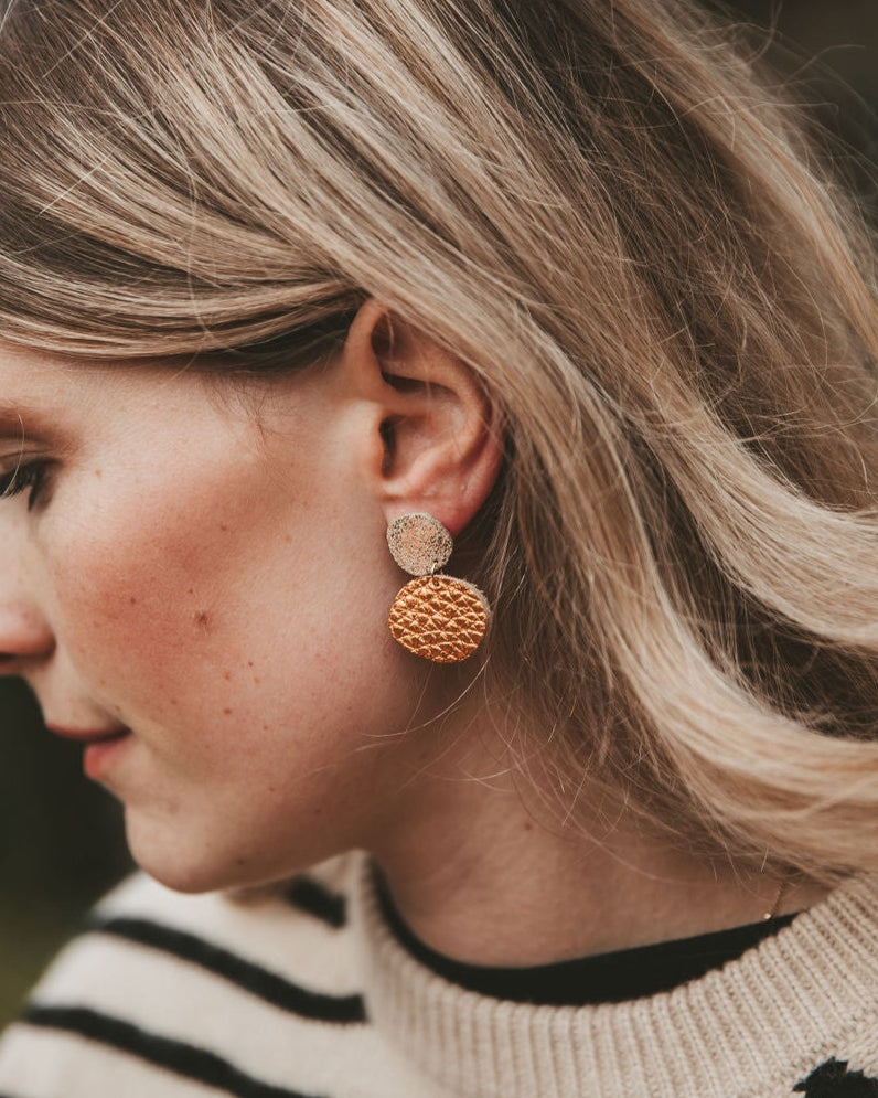 Model wearing the Bili Pop Leather earrings in Metallic Copper