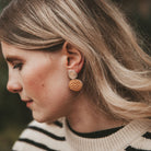 Model wearing the Bili Pop Leather earrings in Metallic Copper