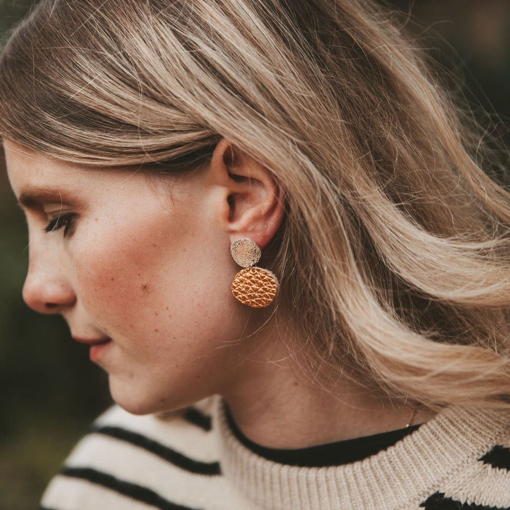 Model wearing the Bili Pop Leather earrings in Metallic Copper