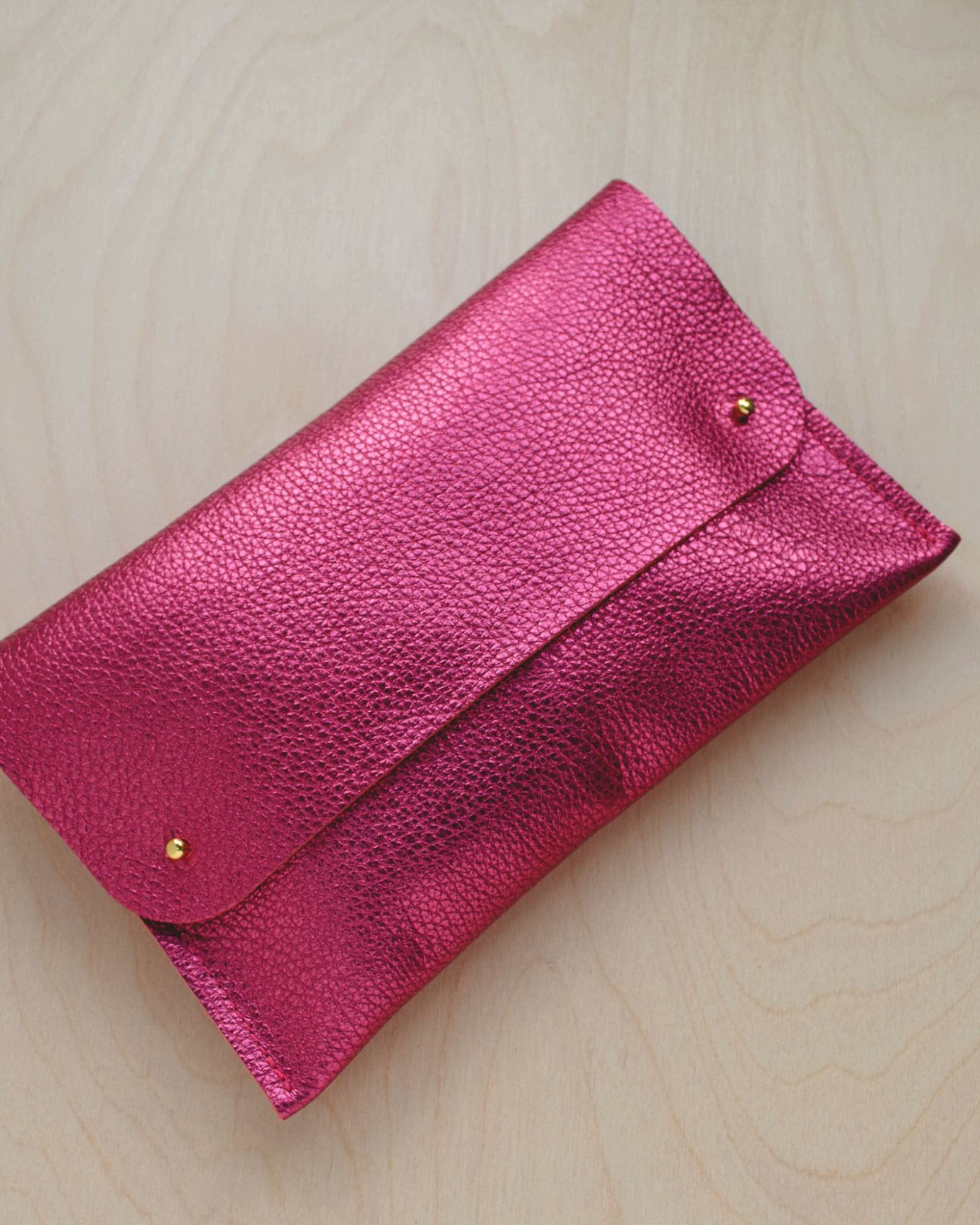 Leather clutch bag in Metallic Rose