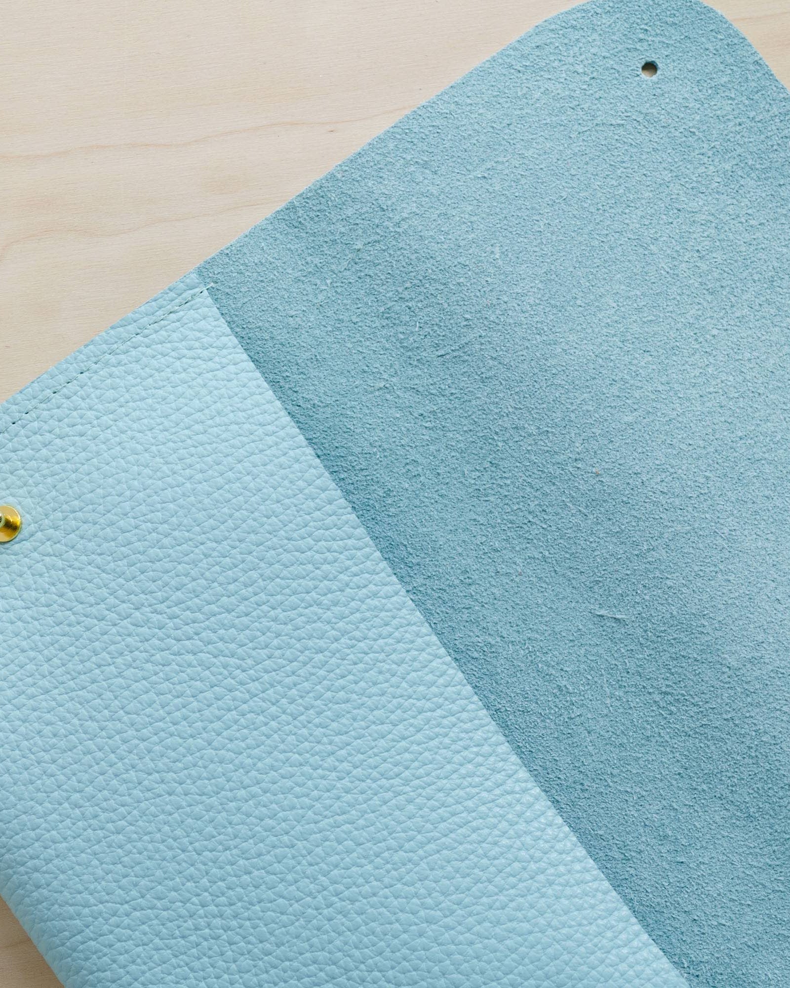 Close up details fo the leather clutch bag in powder blue