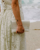 Bridal Pearl White Clutch Bag worn by bride on a beach on her wedding day.