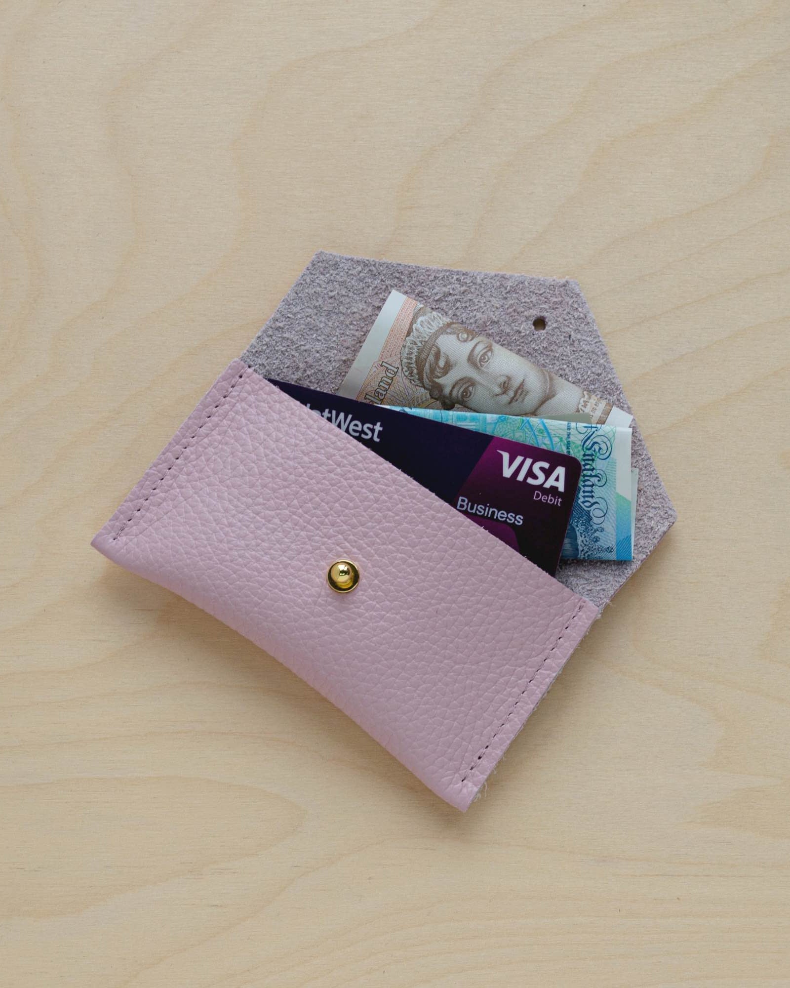 Baby Pink leather card holder with card and cash.