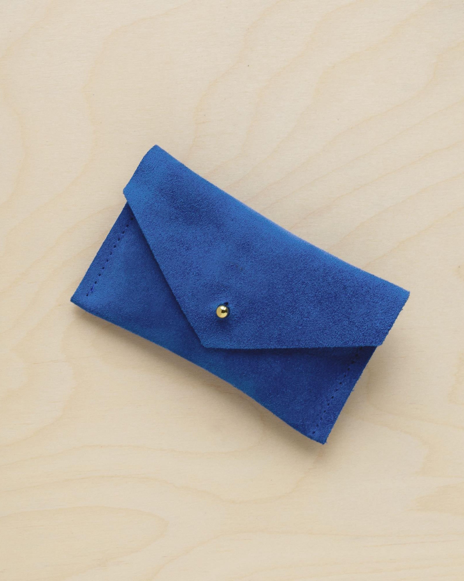 A suede Small Notions Pouch in Cobalt Blue. Complete with a stud for secure closing.