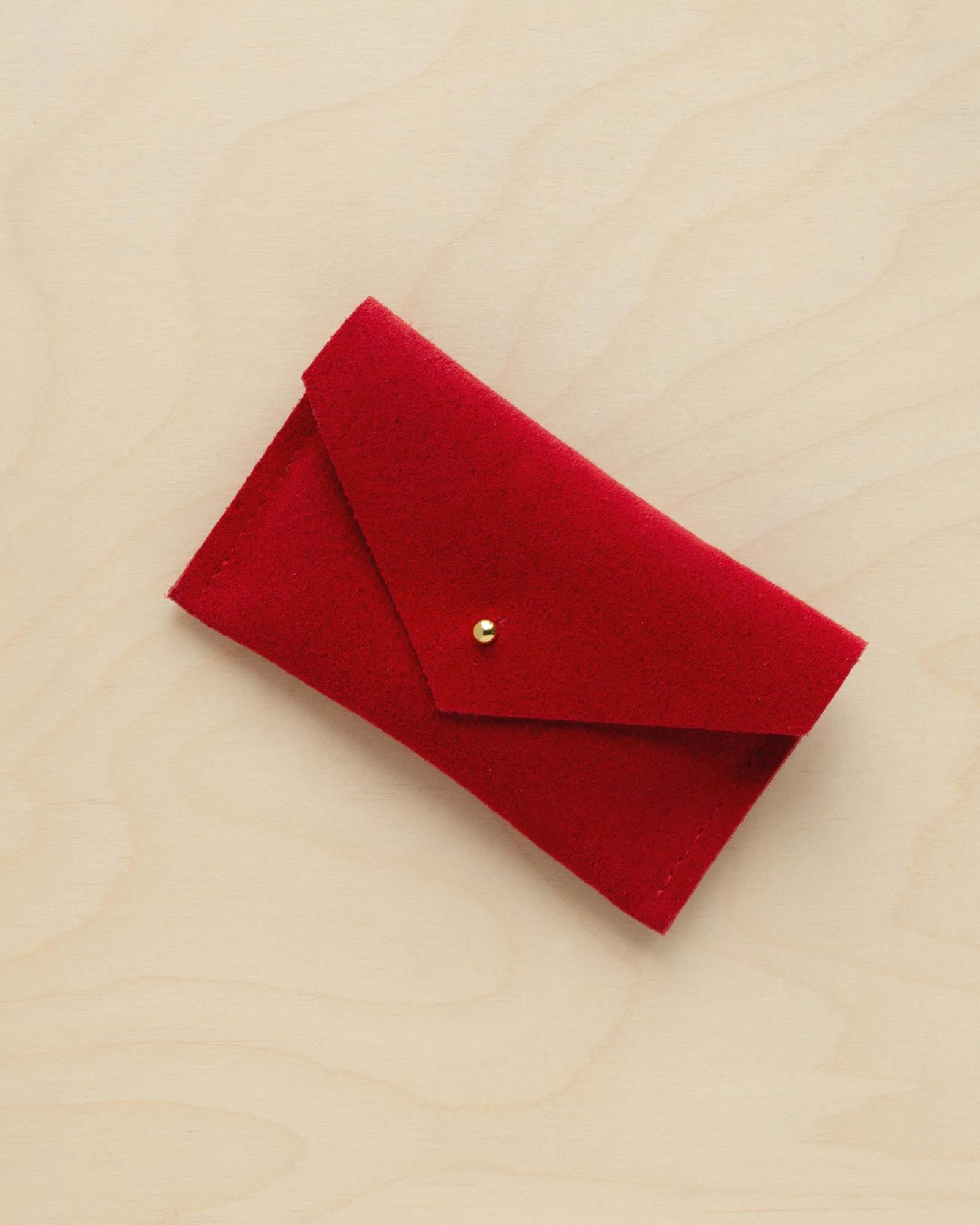 A suede Small Notions Pouch in Crimson Red. Complete with a stud for secure closing.