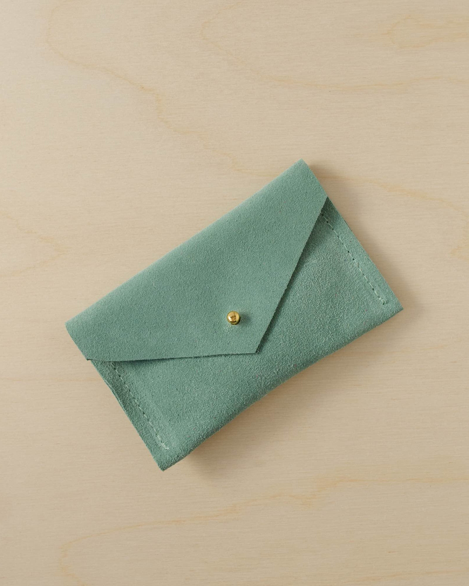 A suede Small Notions Pouch in Mint Green. Complete with a stud for secure closing.