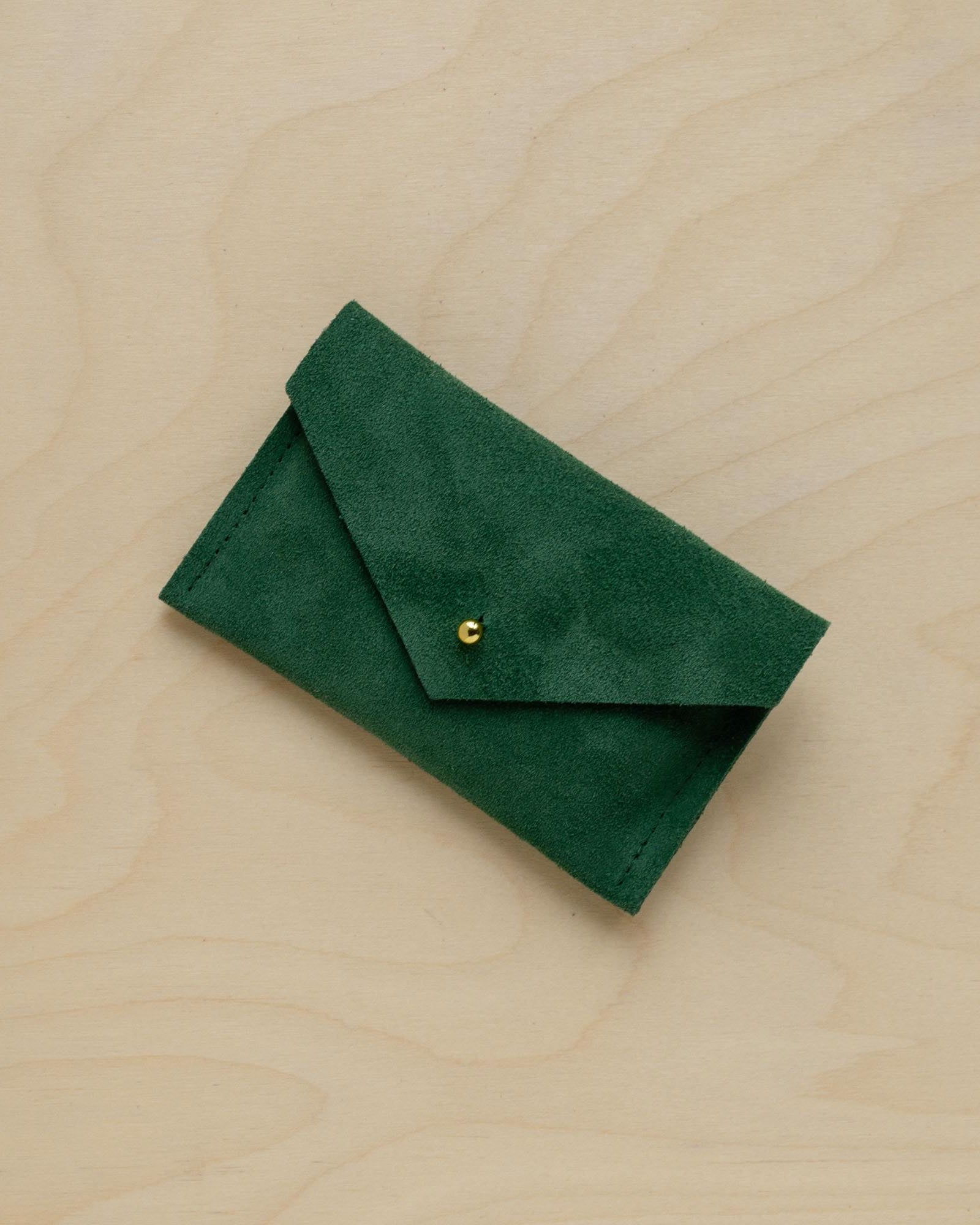 A suede Small Notions Pouch in Moss Green. Complete with a stud for secure closing.