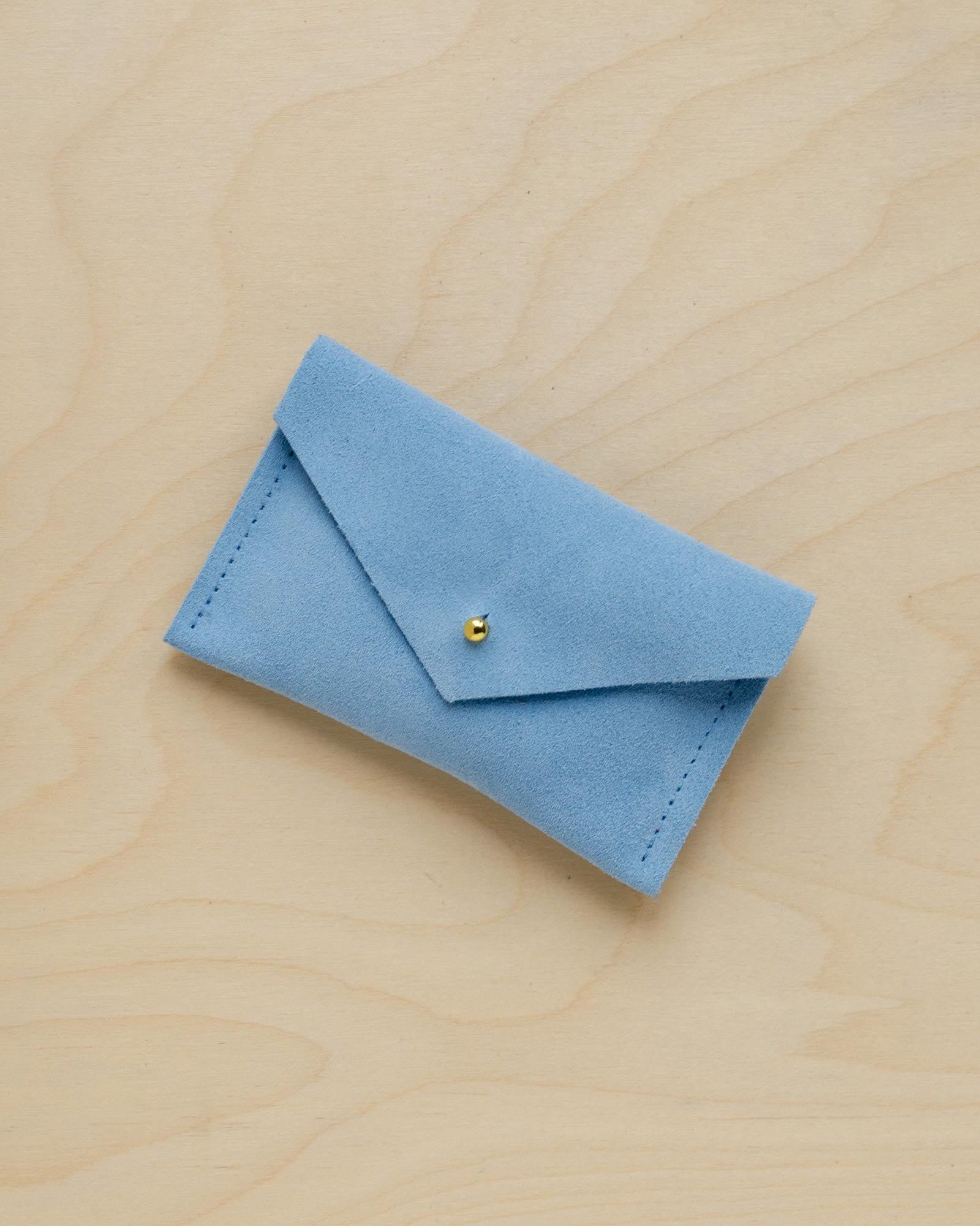 A suede Small Notions Pouch in Pale Blue. Complete with a stud for secure closing.
