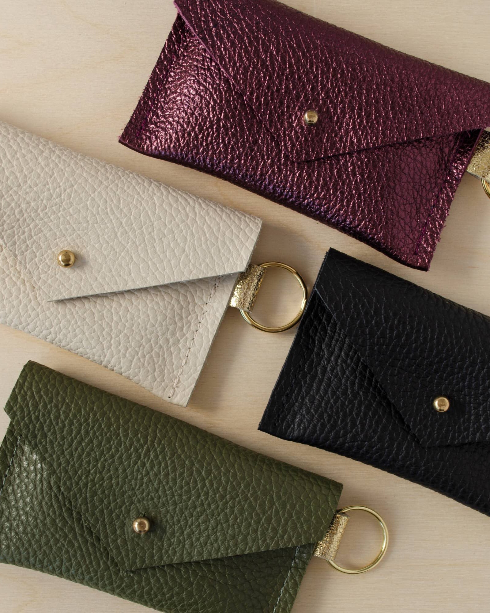 Four leather keyring card holders in black, Metallic Berry, Cream and Olive Green