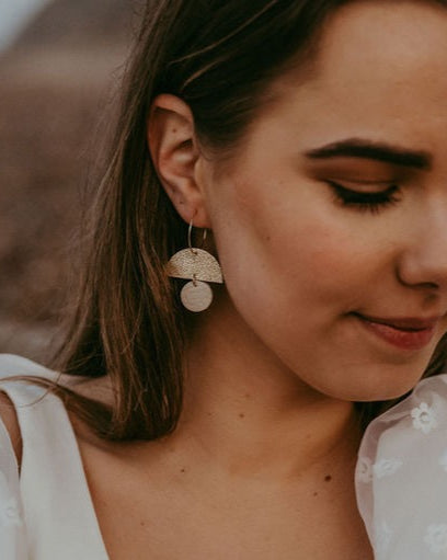 Glittery gold and cream statement hoop earrings being worn by a bride.