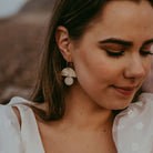 Glittery gold and cream statement hoop earrings being worn by a bride.