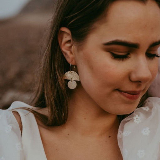 Glittery gold and cream statement hoop earrings being worn by a bride.