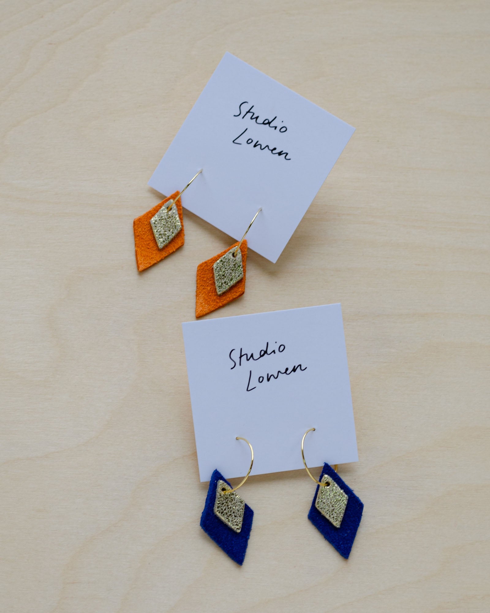 Two pairs of the Lia Hoop Earrings in Ultramarine Blue and Clementine Orange.