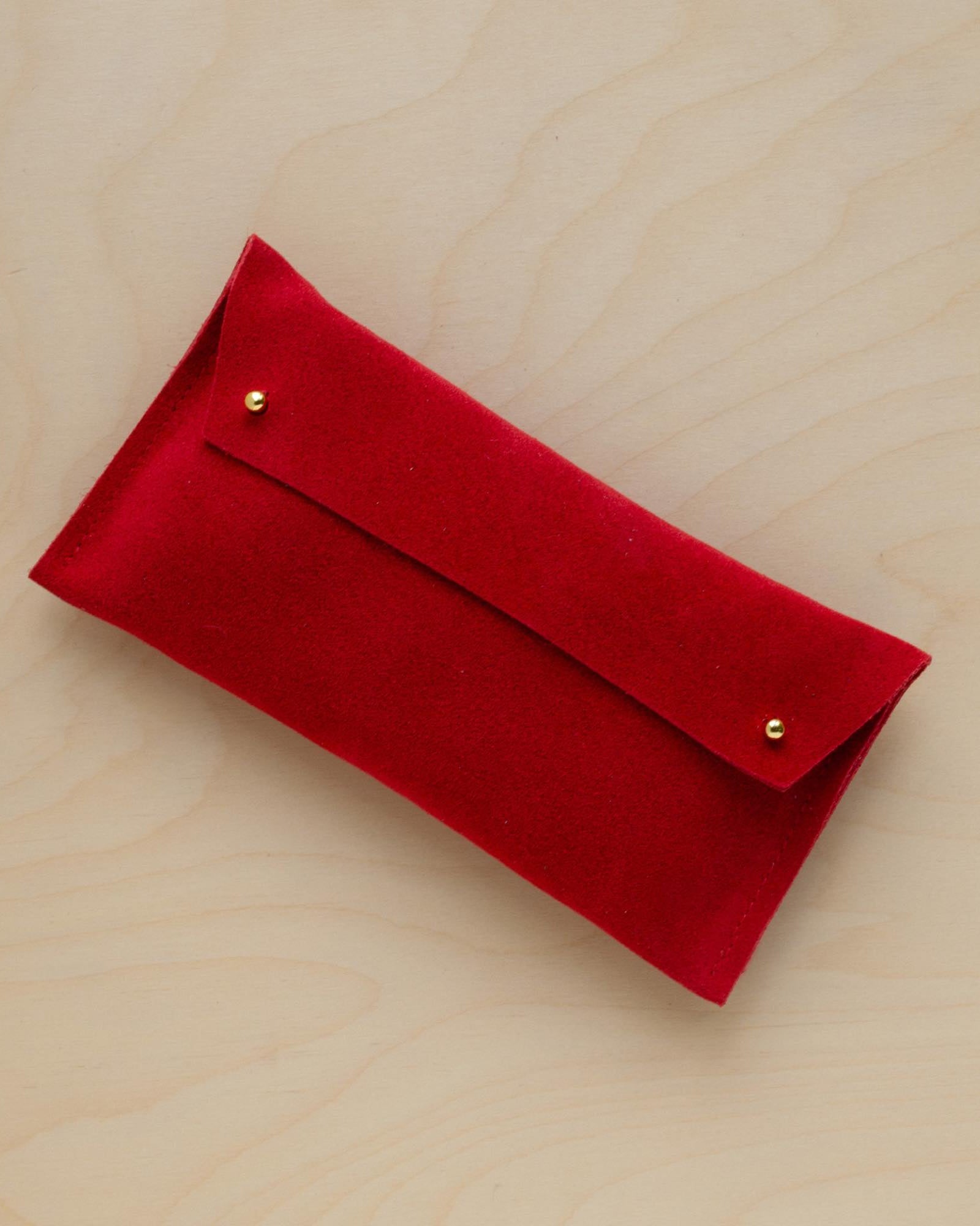 The suede pen case in Crimson Red. Featuring a double stud.