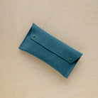 The suede pen case in Teal. Featuring a double stud.