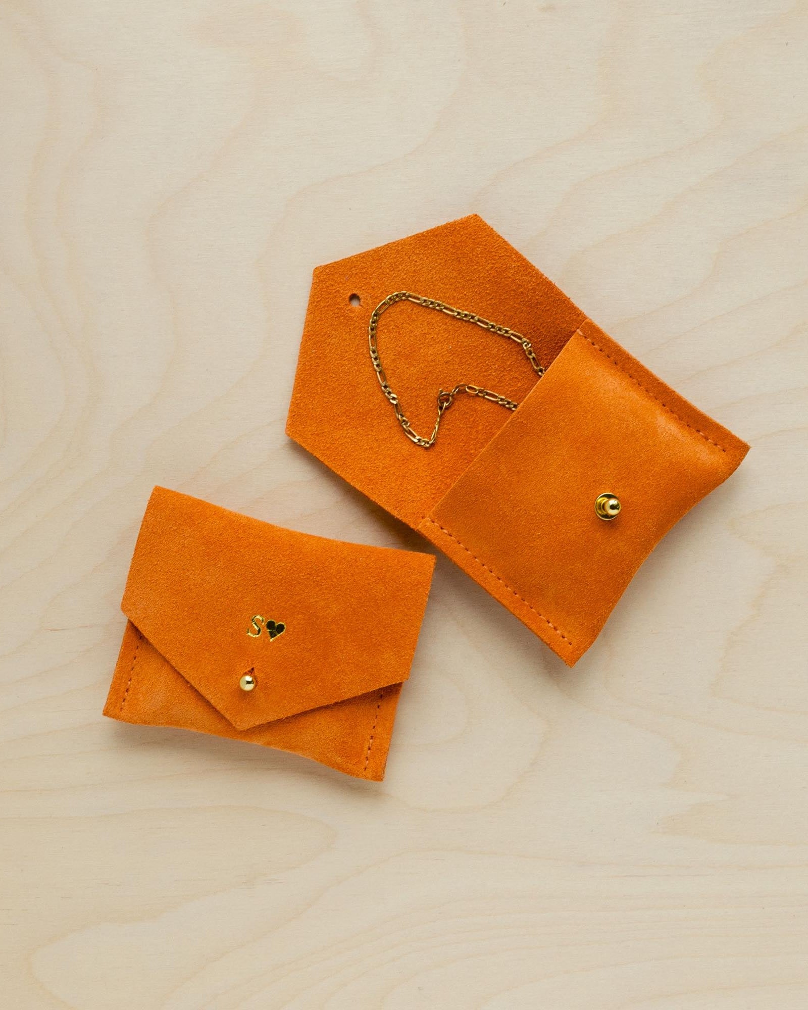 A suede Stitch Markers pouch in Clementine Orange. Complete with a stud for secure closing. This pouch has been personalised.