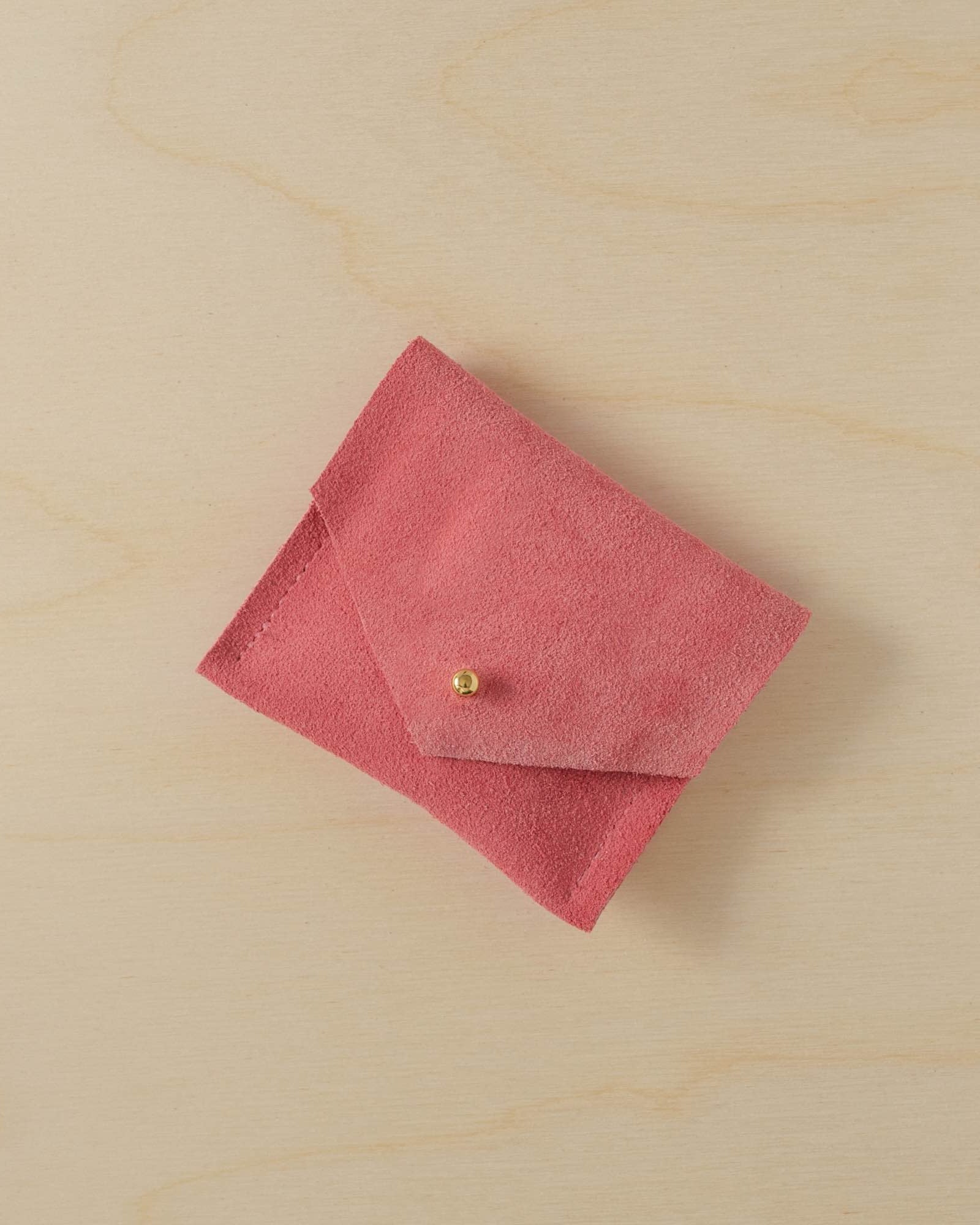 A suede Stitch Markers pouch in Coral Pink. Complete with a stud for secure closing.