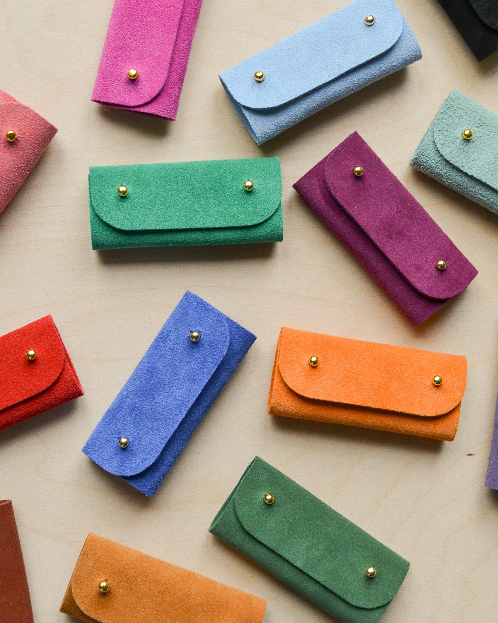 A collection of the sewing needle cases laid out on the table.