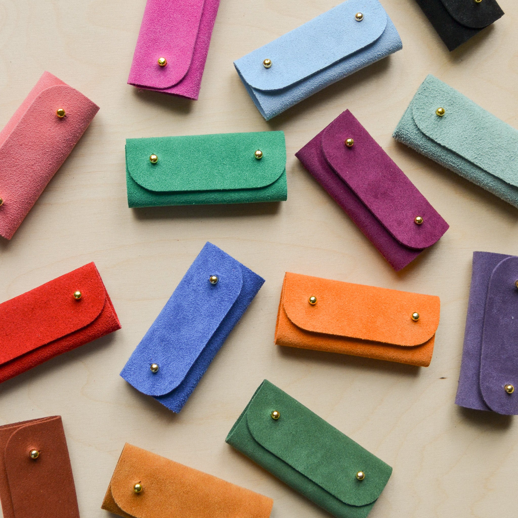 A collection of the sewing needle cases laid out on the table.