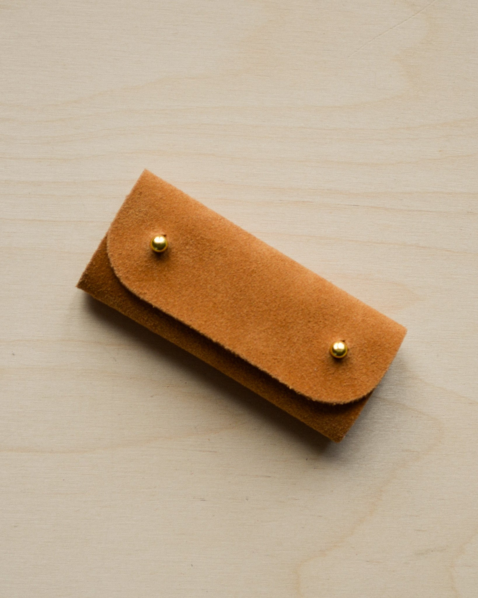 Tan brown mini sewing needle case.