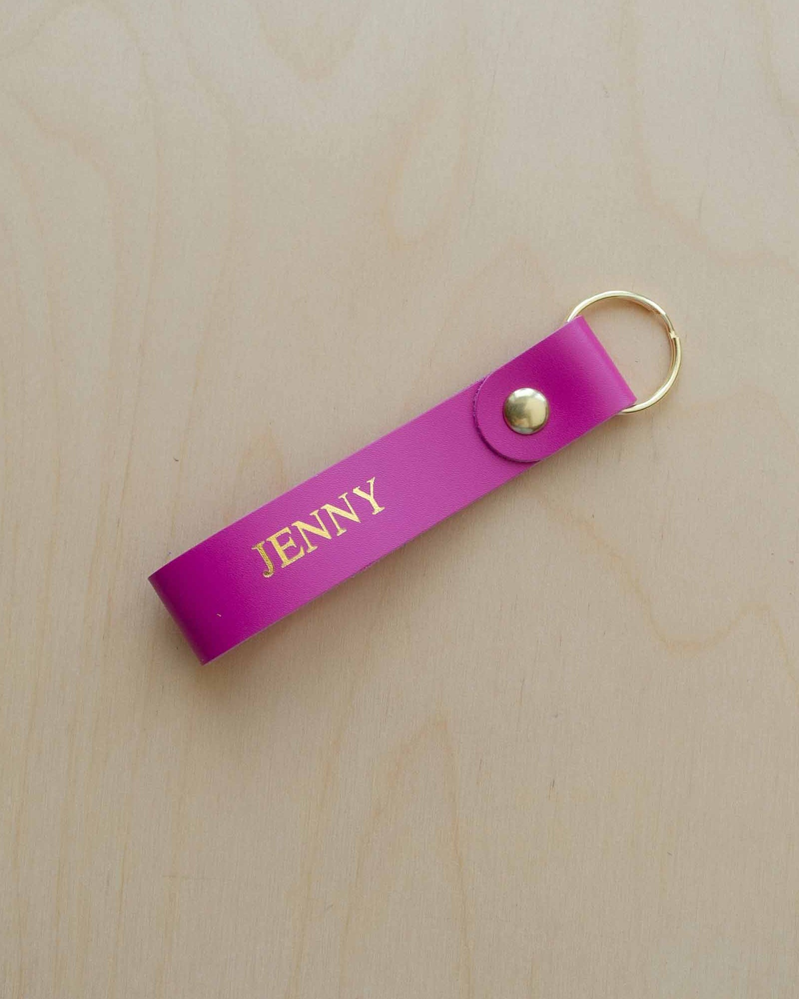 Pink leather keyring with the name "Jenny" written on it in gold foil.
