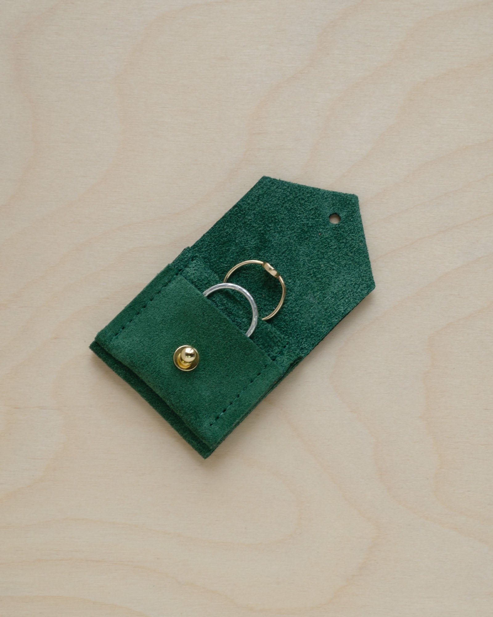 An open and in use, Moss Green Wedding Ring Pouch in suede.