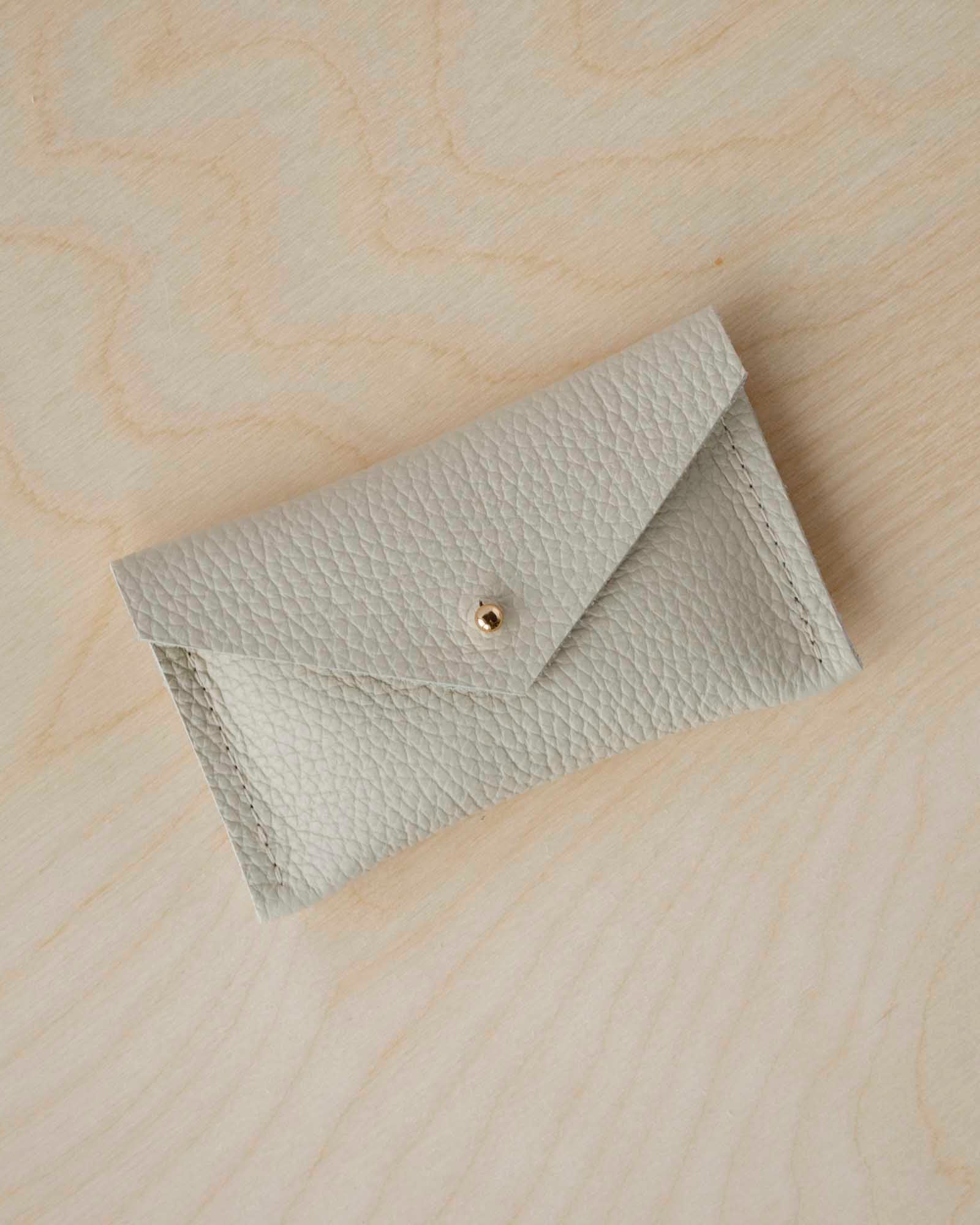 Cream leather card purse with simple envelope design.
