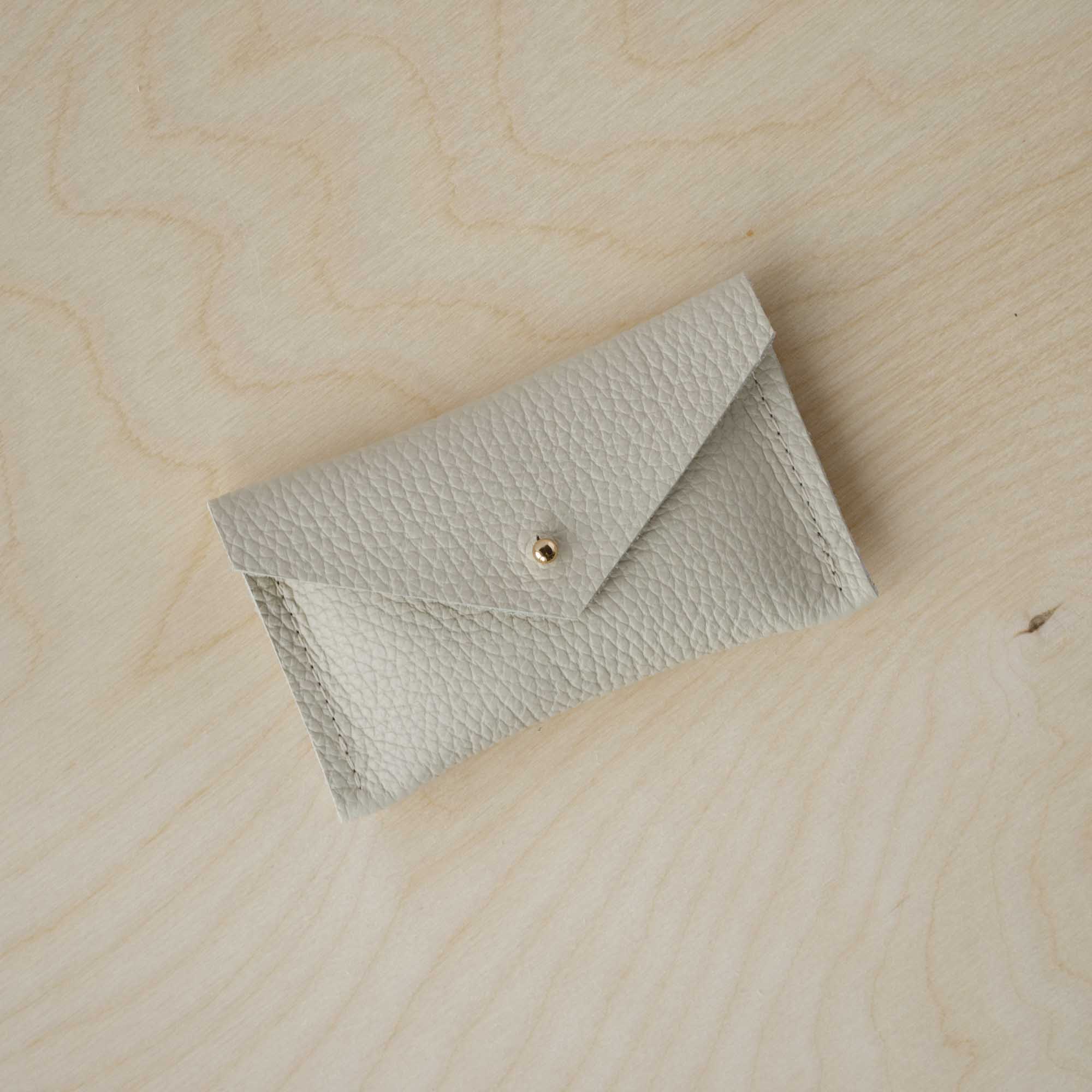 Cream leather card purse with simple envelope design.