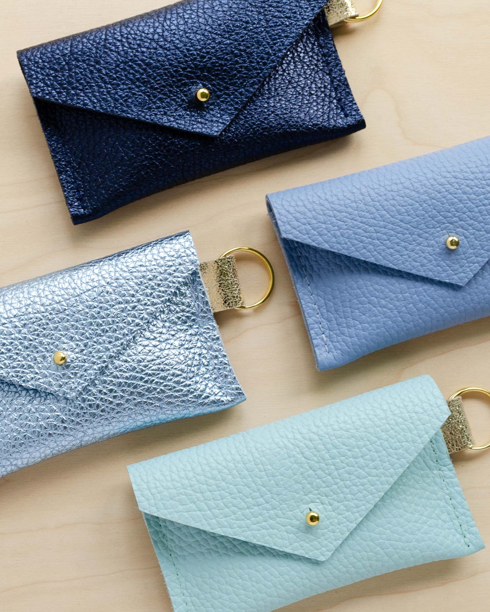Four leather keyring card holder in Metallic Navy, Metallic Diamond, Seaglass and Powder Blue.
