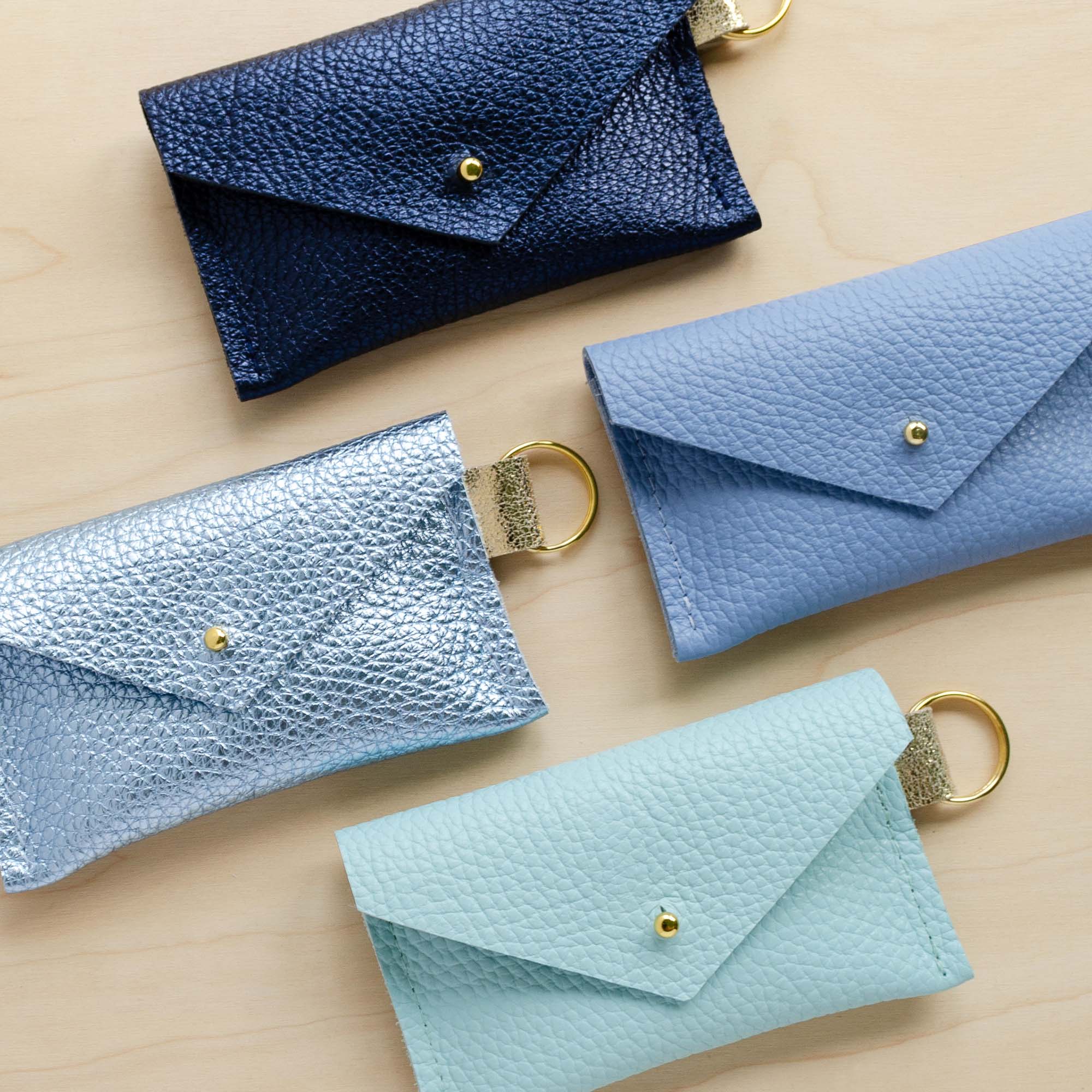 Four leather keyring card holder in Metallic Navy, Metallic Diamond, Seaglass and Powder Blue.