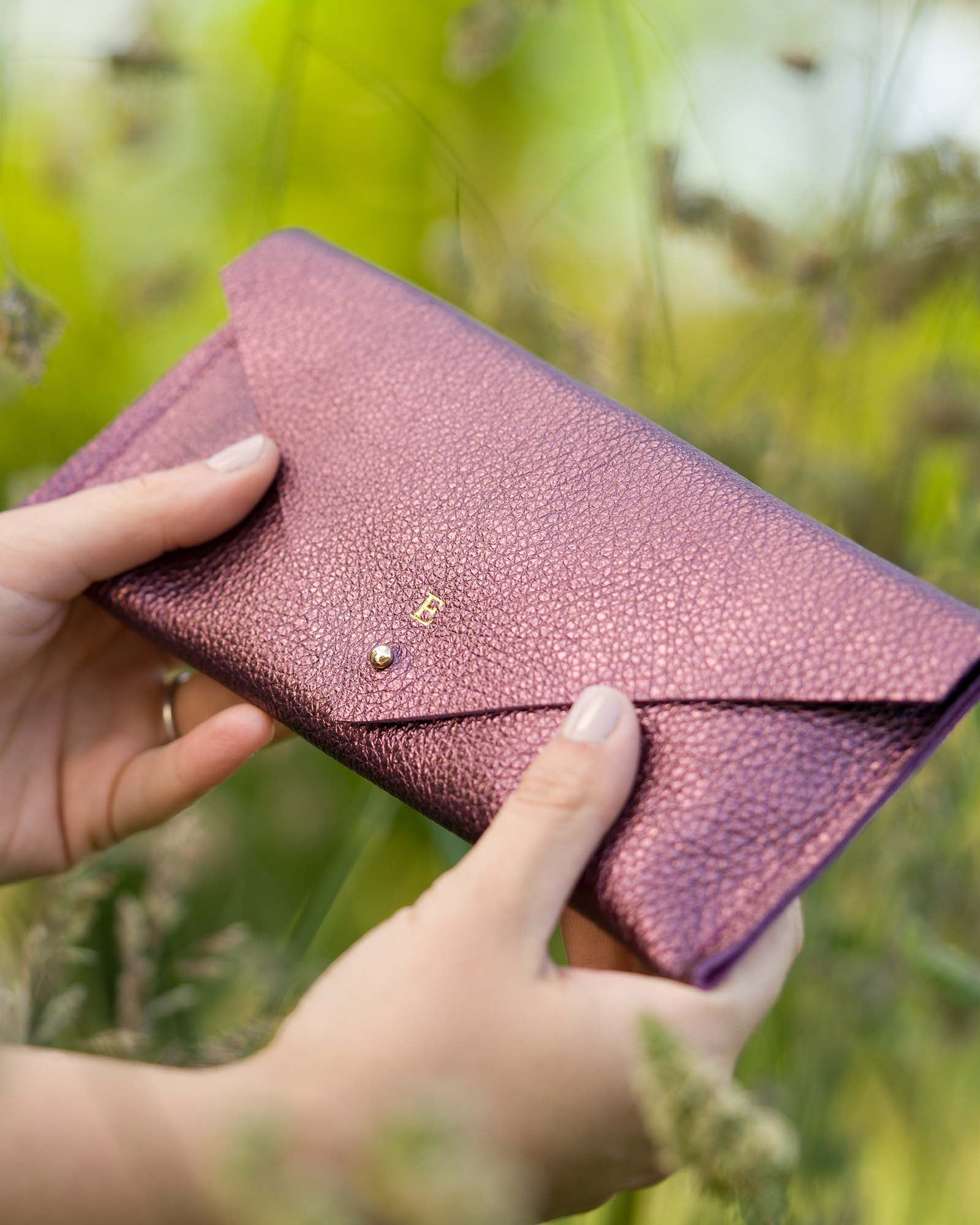 Personalised leather clutch purse in metallic berry purple, personalised with he initial E.