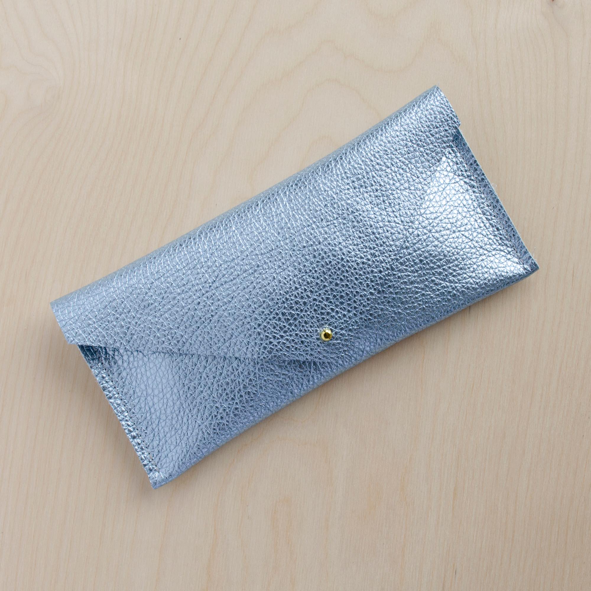 Metallic diamond pale blue compact leather clutch bag with simple envelope design and gold fastening.