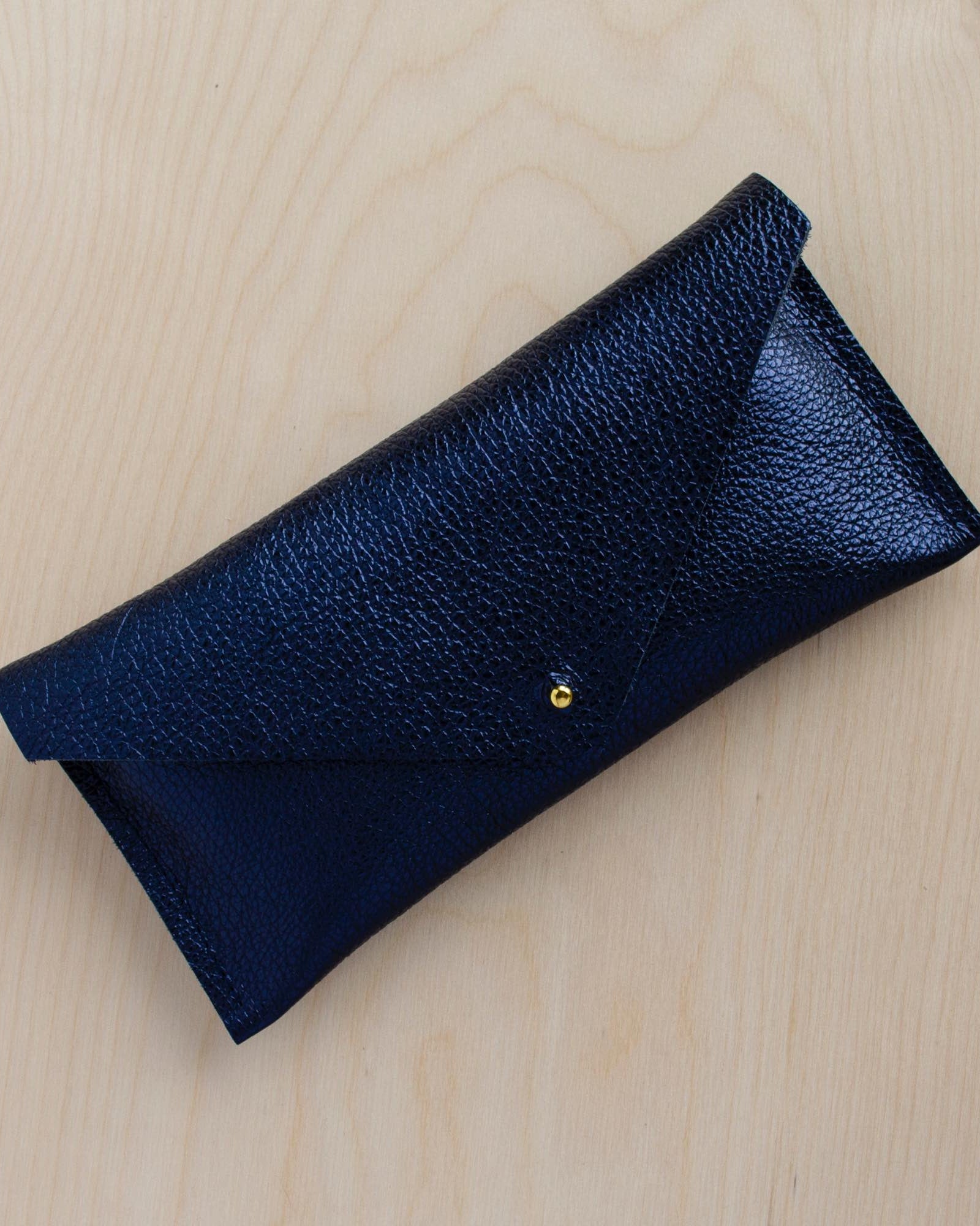 Metallic navy clutch purse made with leather.