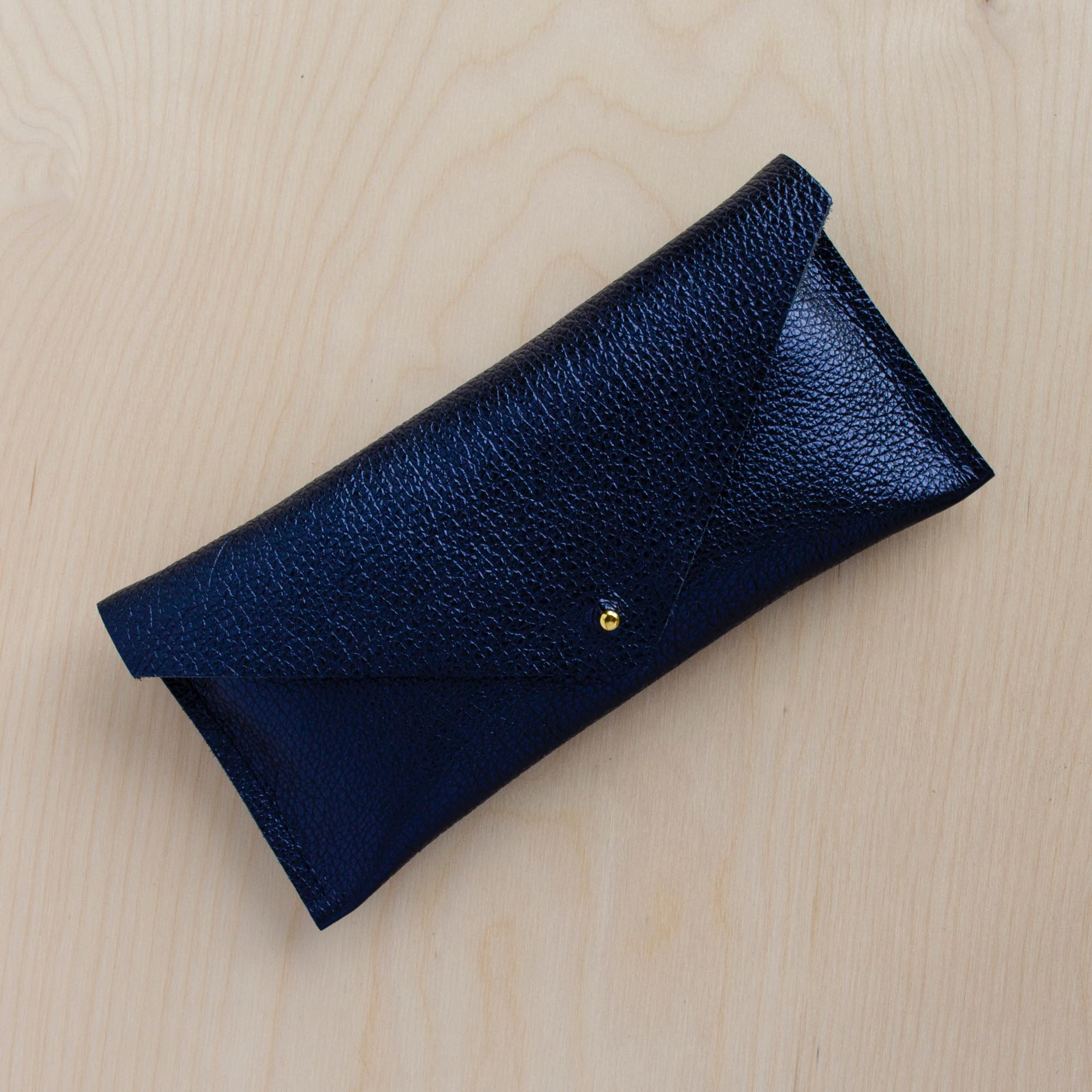 Metallic navy clutch purse made with leather.