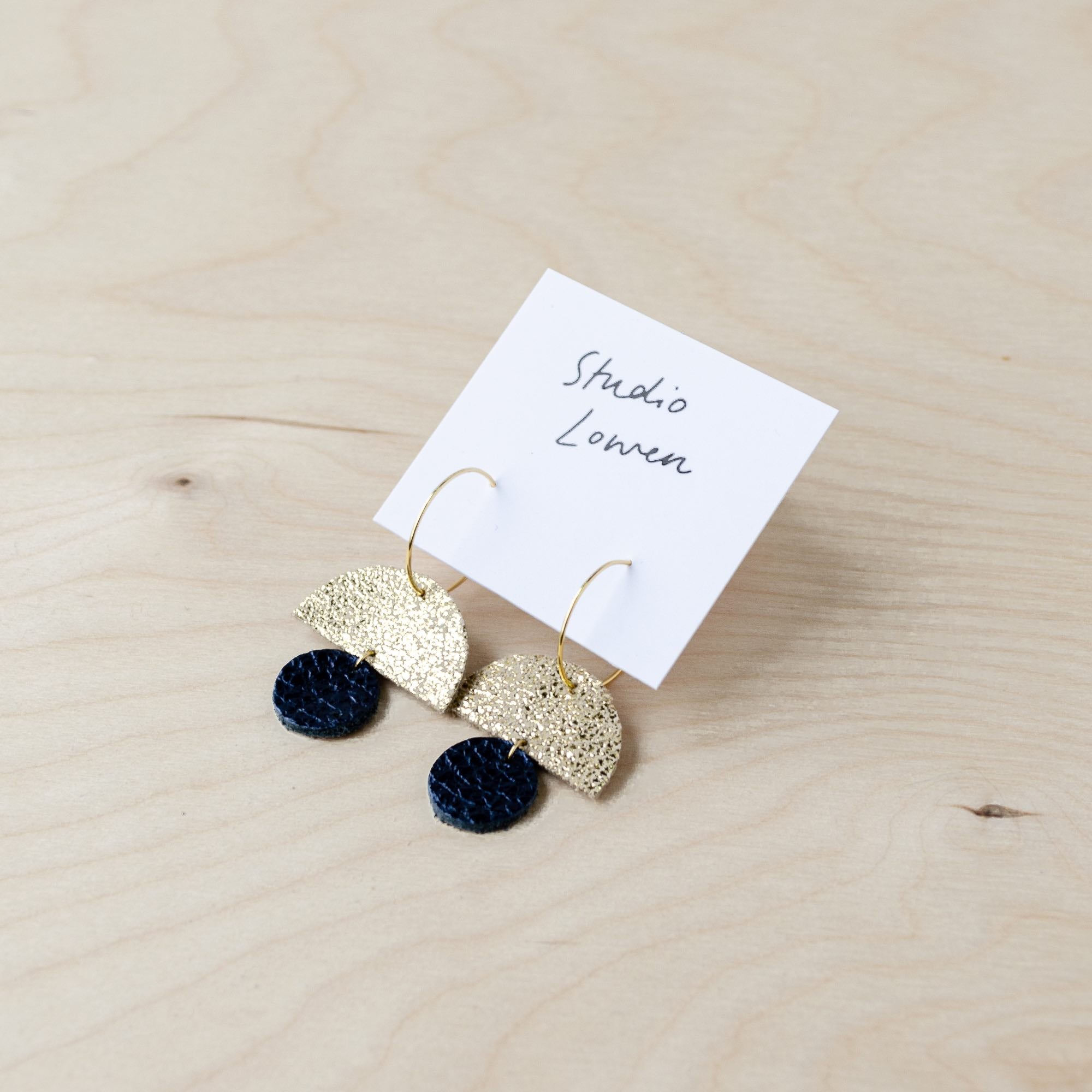 Sunrise hoop earrings in black leather and shimmer gold