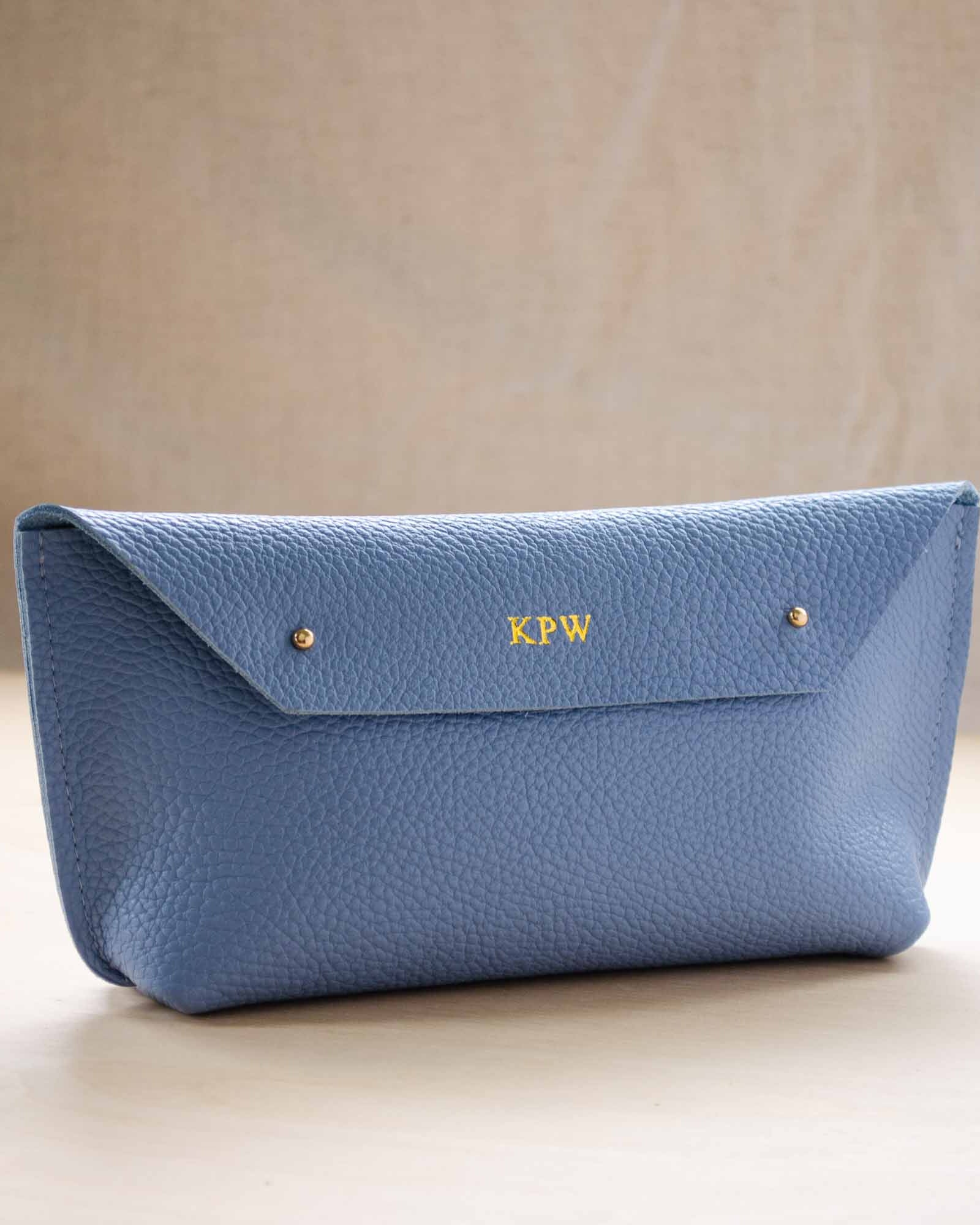 Ailla Leather clutch bag, with gold monogram.