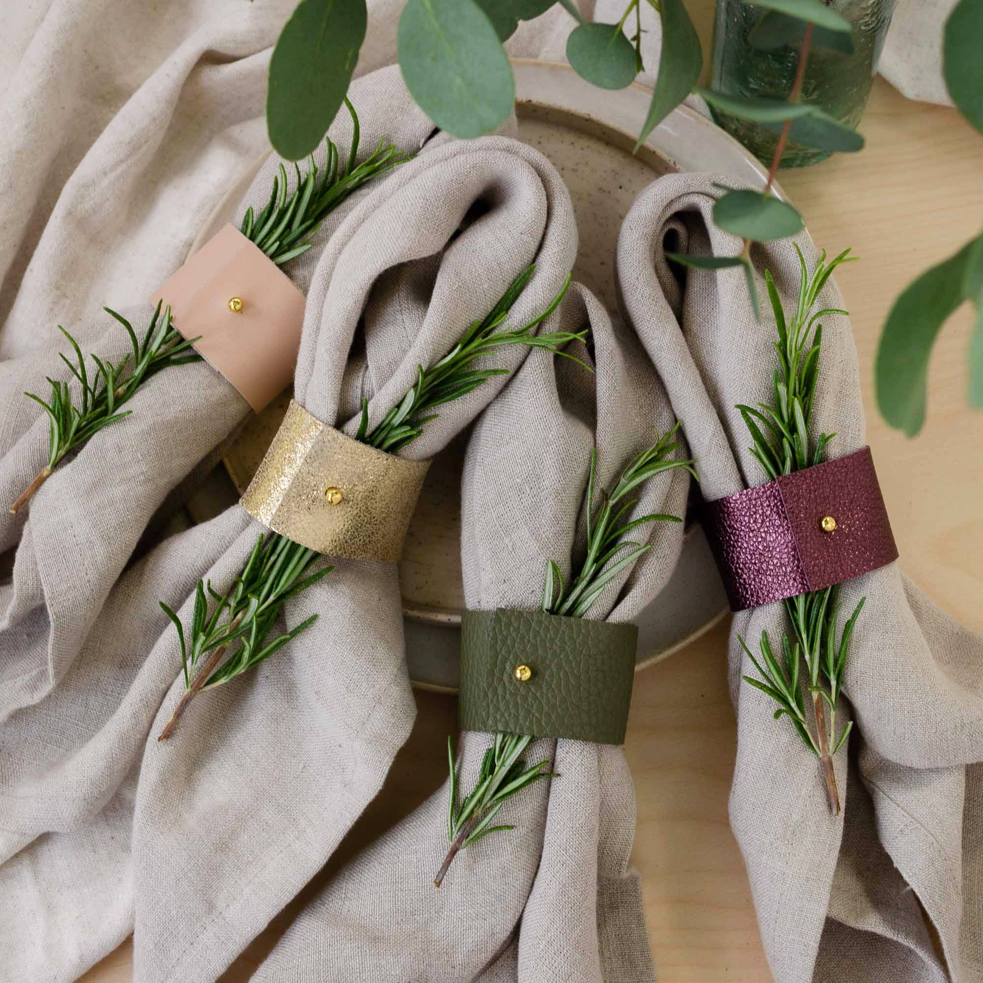 Leather napkin rings in pink, gold, olive green and berry purple.