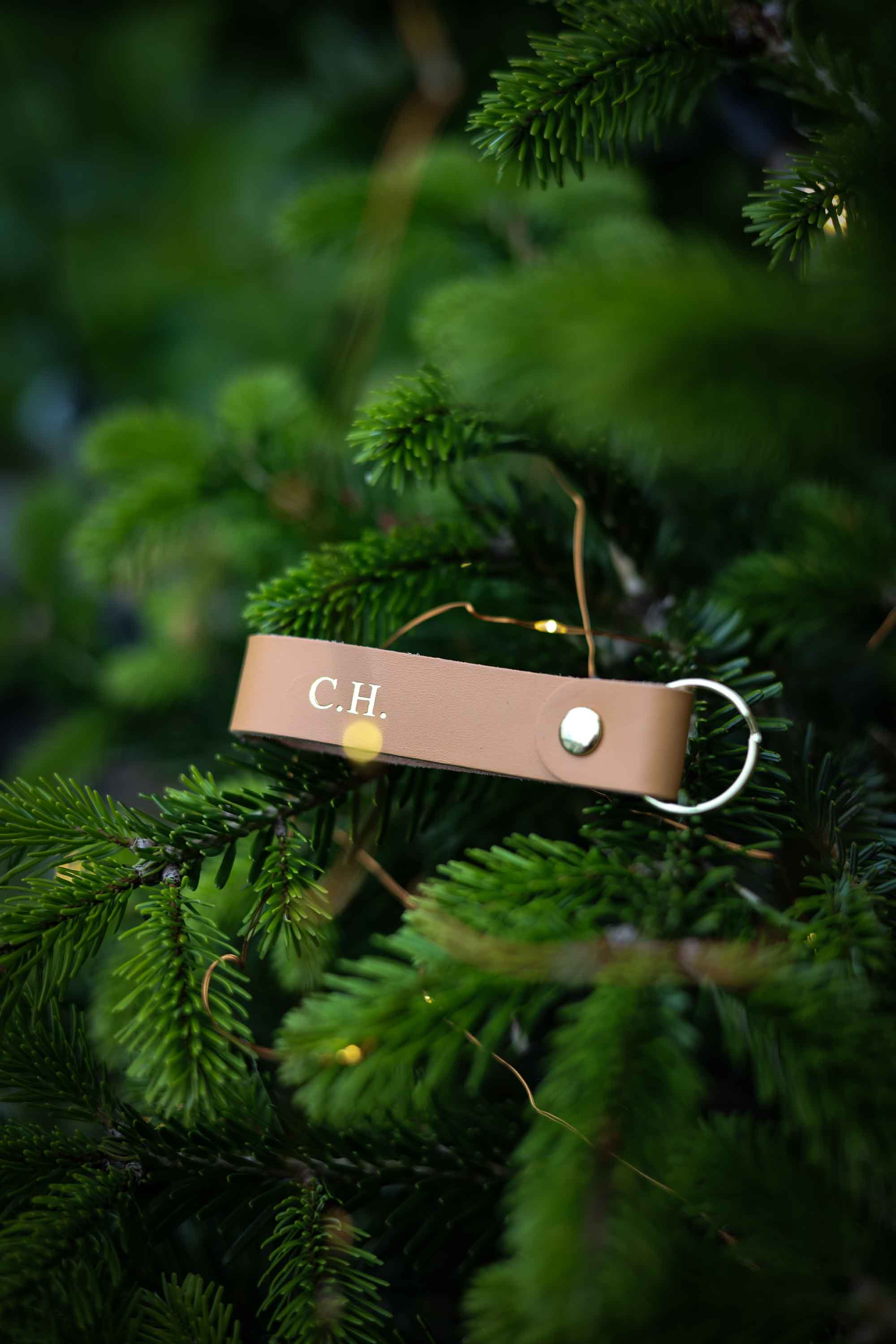Brown leather keyring with the initials C.H. on it, in a Christmas tree.