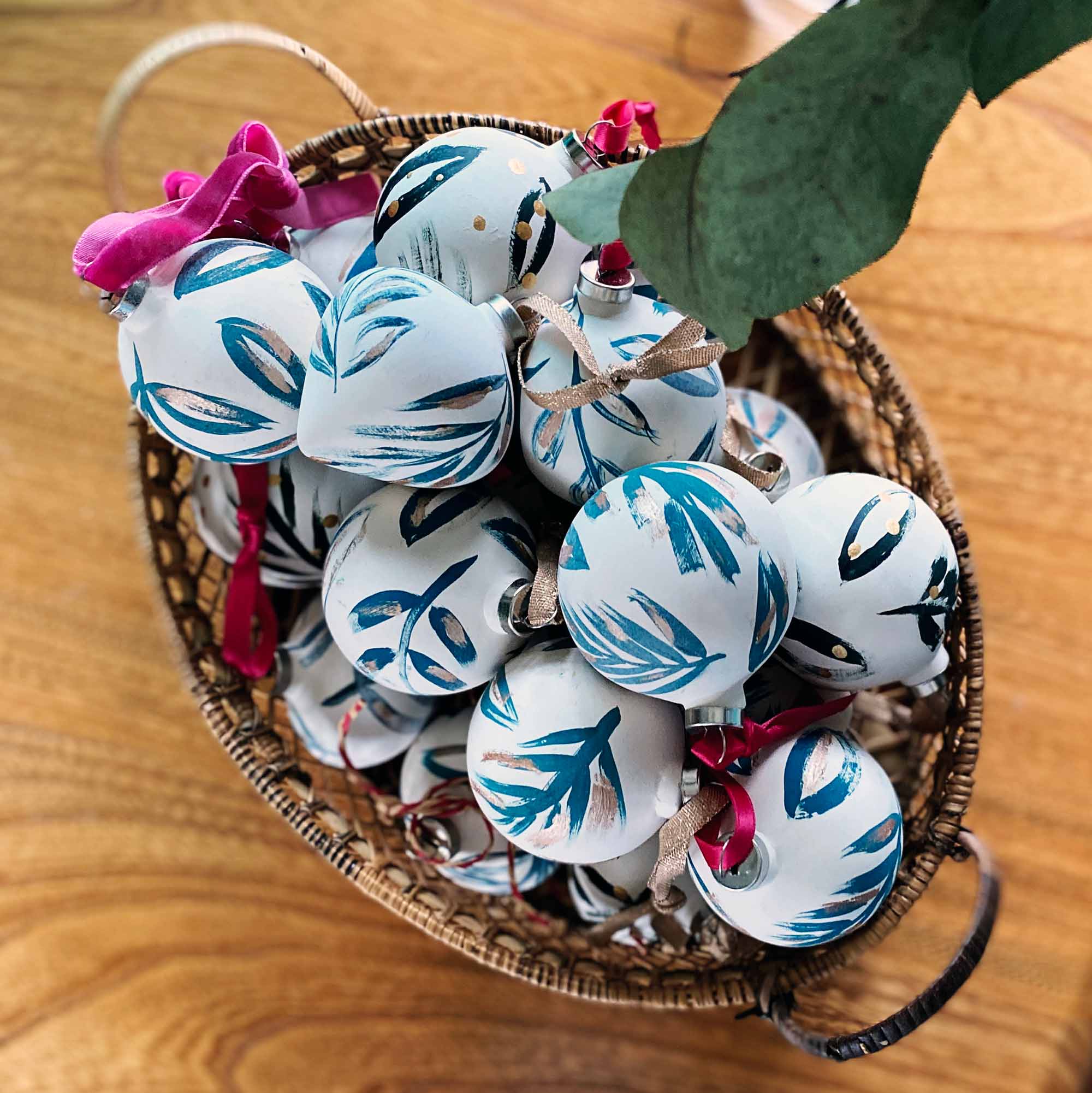 Handpainted ceramic baubles with a green botanical design.