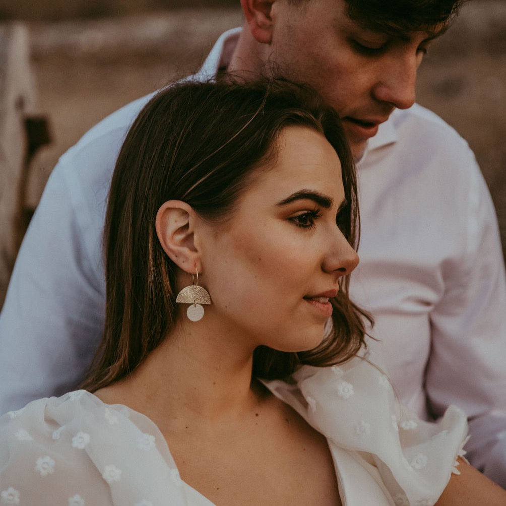 Bride and groom on their wedding day, bride wears gold and cream moon shaped statement hoop earrings.