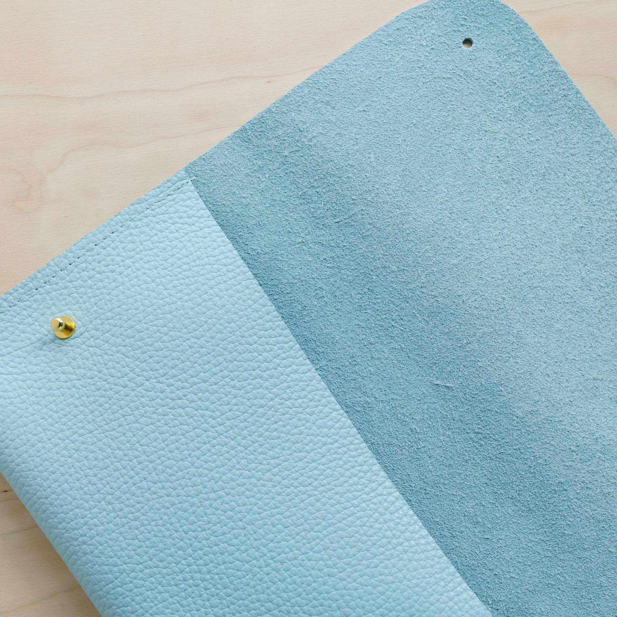 Close up details fo the leather clutch bag in powder blue