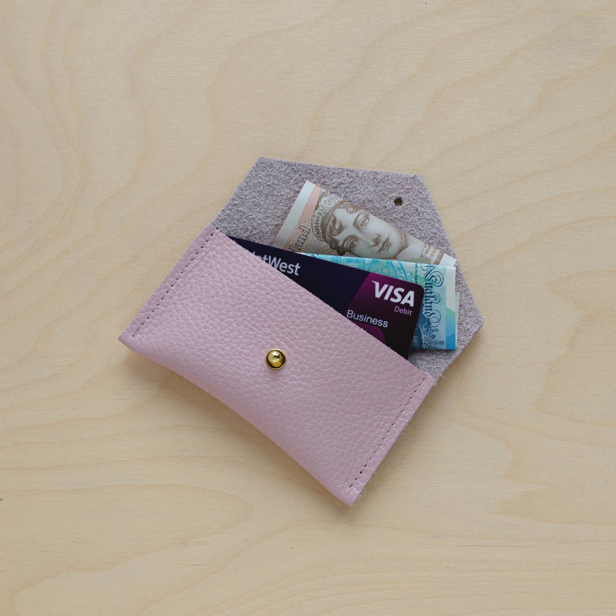 Baby Pink leather card holder with card and cash.