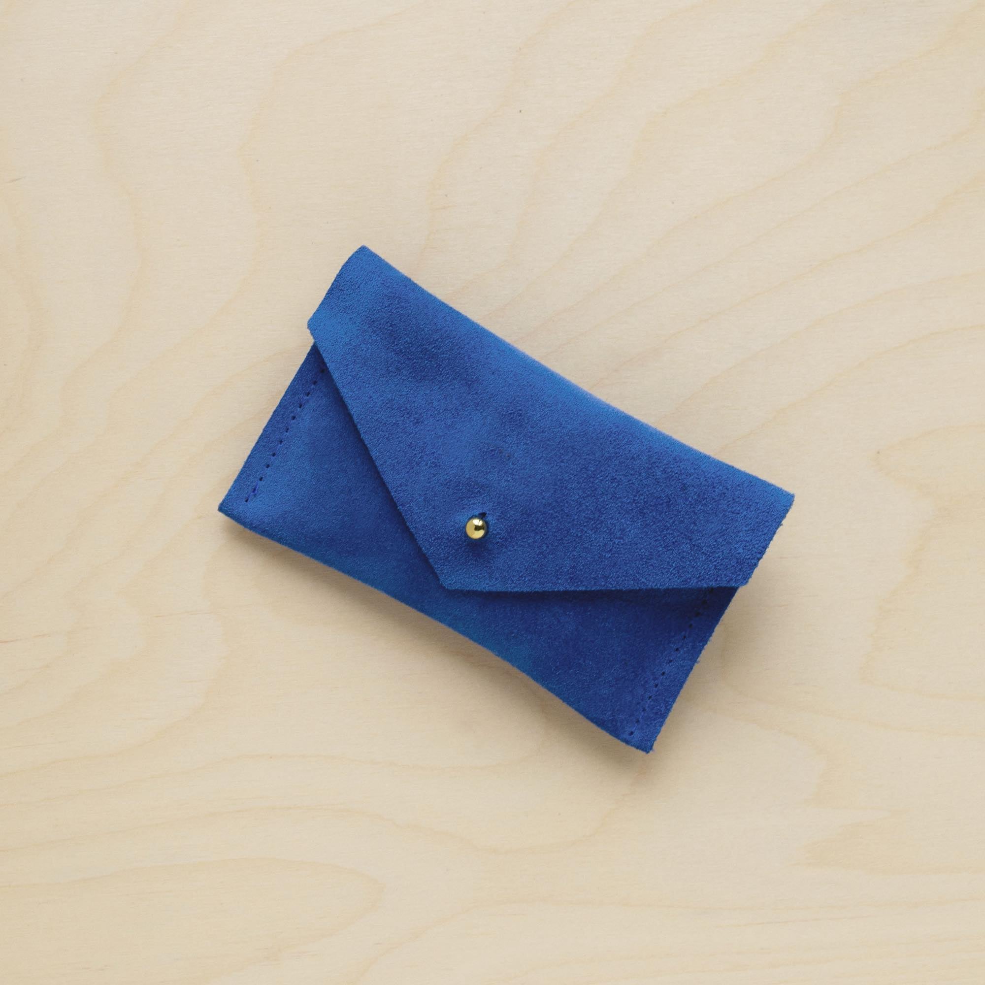 A suede Small Notions Pouch in Cobalt Blue. Complete with a stud for secure closing.
