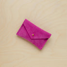 A suede Small Notions Pouch in Fuchsia Pink. Complete with a stud for secure closing.