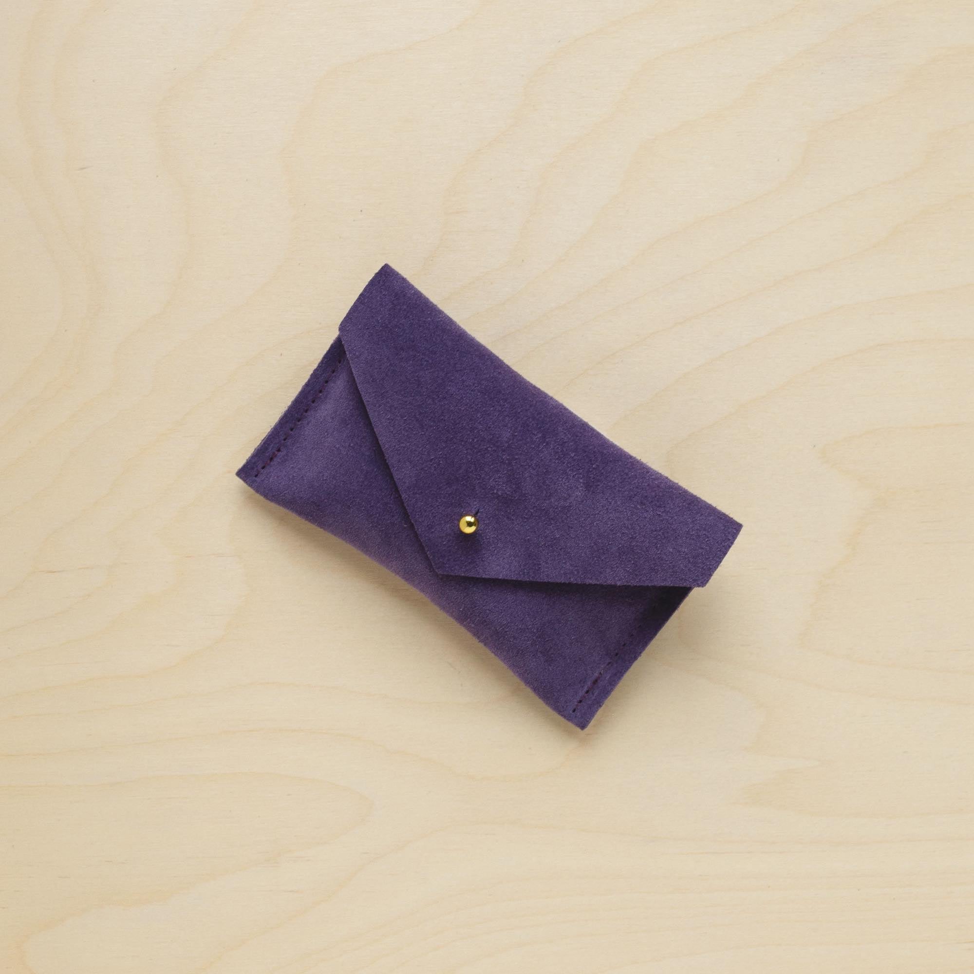 A suede Small Notions Pouch in Grape Purple. Complete with a stud for secure closing.