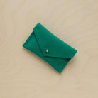 A suede Small Notions Pouch in Jade Green. Complete with a stud for secure closing.